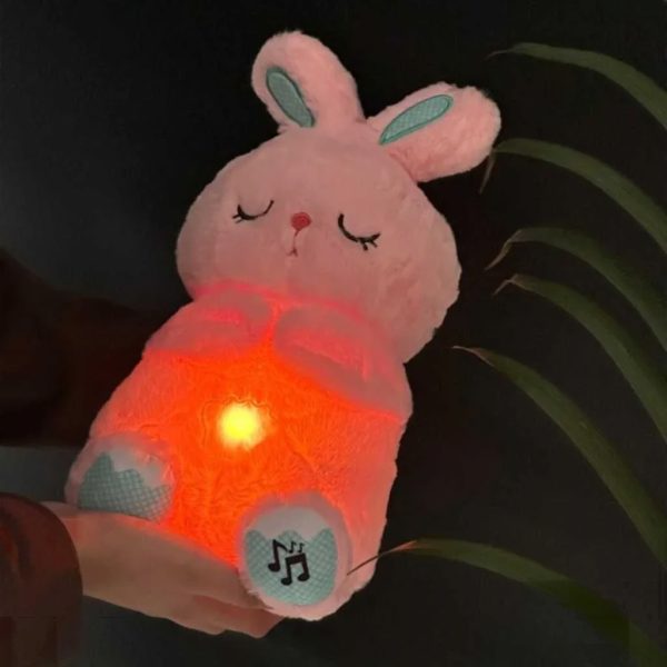The soft pink Plush Breathing Cute Rabbit Toy with Sensory Electronic Soft Tech features embroidered sleeping eyes, teal-accented paws with a music note icon, and a glowing warm orange belly light.